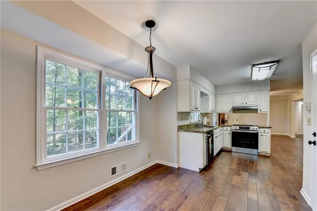 a bathroom with a granite countertop sink a toilet and a mirror