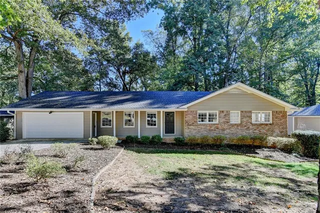 a view of a house with a yard and large trees