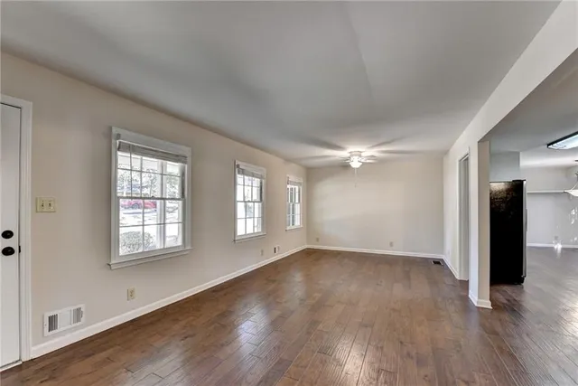 a view of a room with wooden floor and a kitchen
