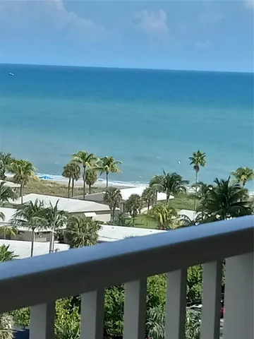 a view of a lake with a floor to ceiling window and potted plants