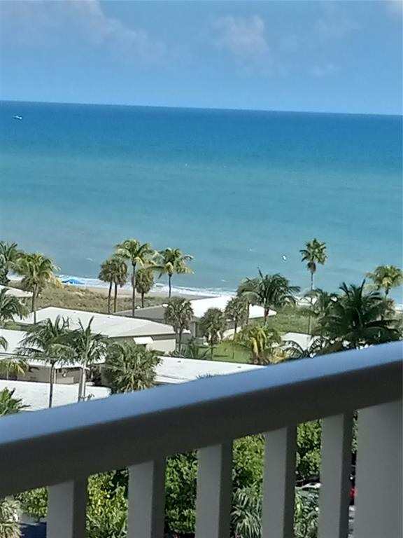a view of a lake with a floor to ceiling window and potted plants
