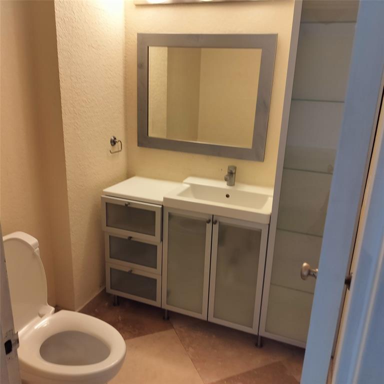 1200 Hibiscus Avenue, Unit 903 Pompano Beach, FL 33062 - Photo 11 of 20 a bathroom with a toilet sink and mirror