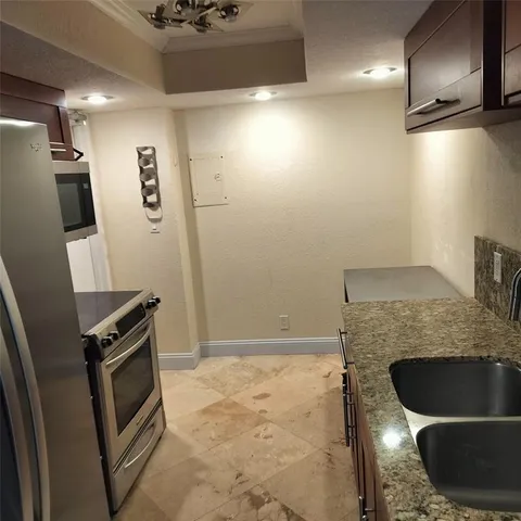 a kitchen with granite countertop a stove and a refrigerator