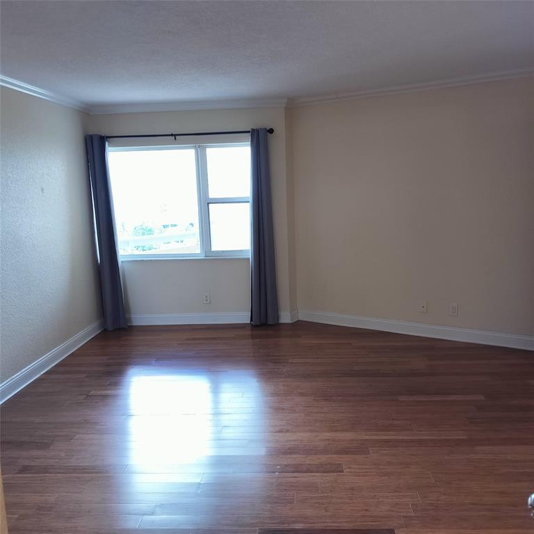 1200 Hibiscus Avenue, Unit 903 Pompano Beach, FL 33062 - Photo 8 of 20 an empty room with wooden floor and windows