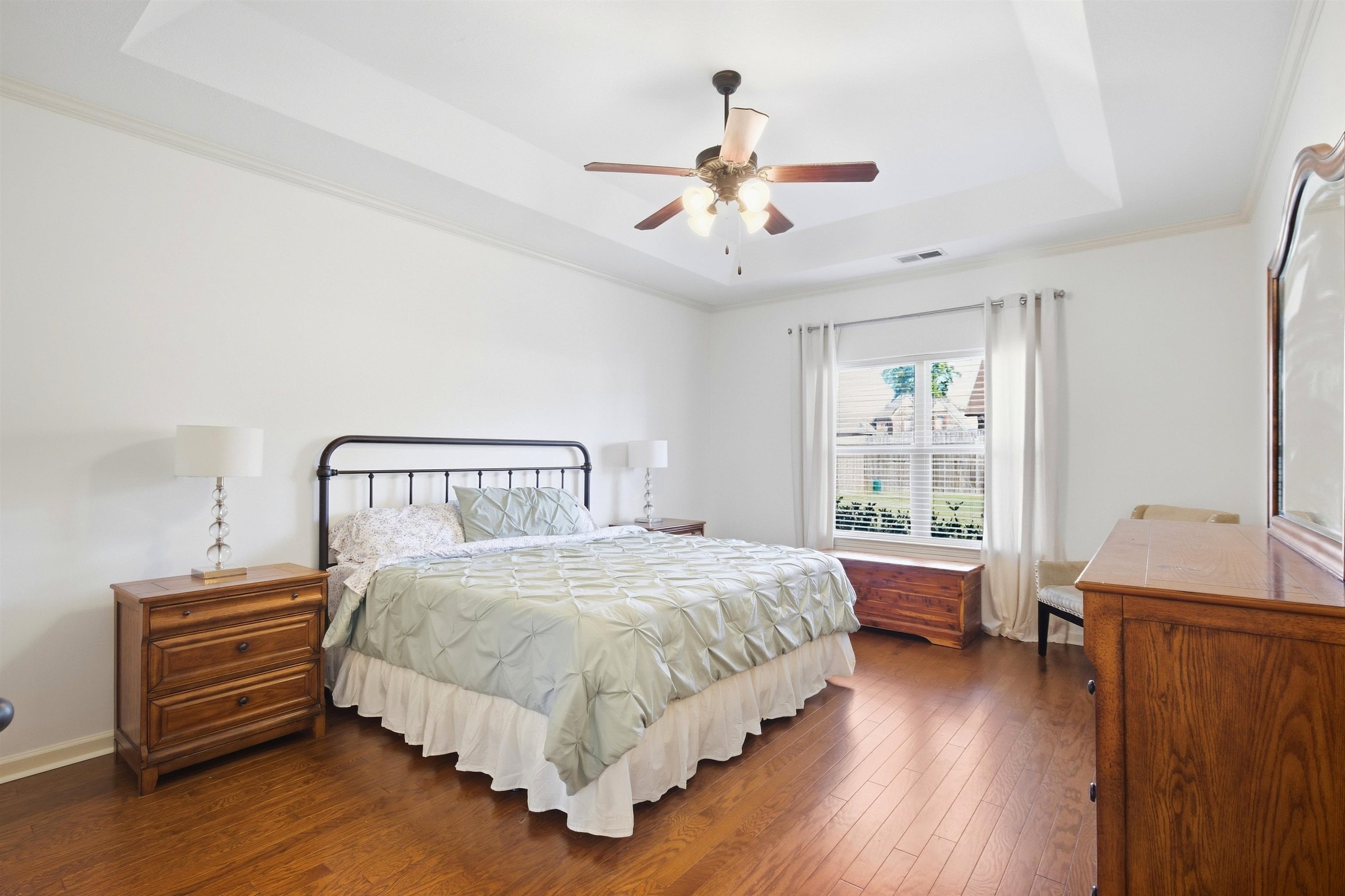 7920 Pips Ridge Lane Bartlett, TN 38133 - Photo 14 of 40 Tray ceiling with crown molding, wood-finish flooring, ceiling fan, and window with blinds