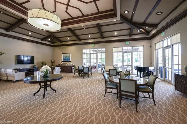 a view of a white house with a dining table and chairs