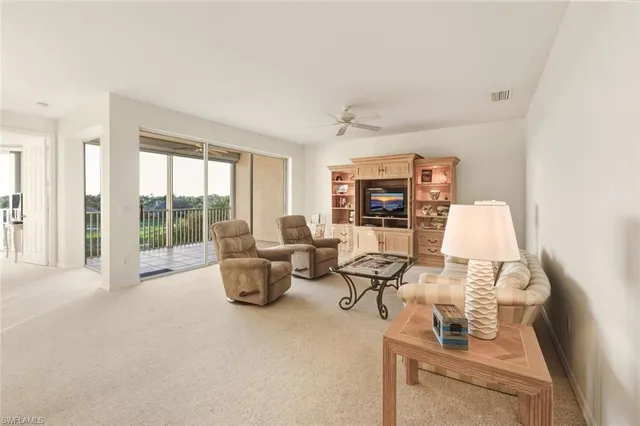 a living room with furniture and a floor to ceiling window