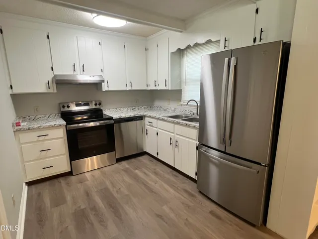 a kitchen with white cabinets and stainless steel appliances