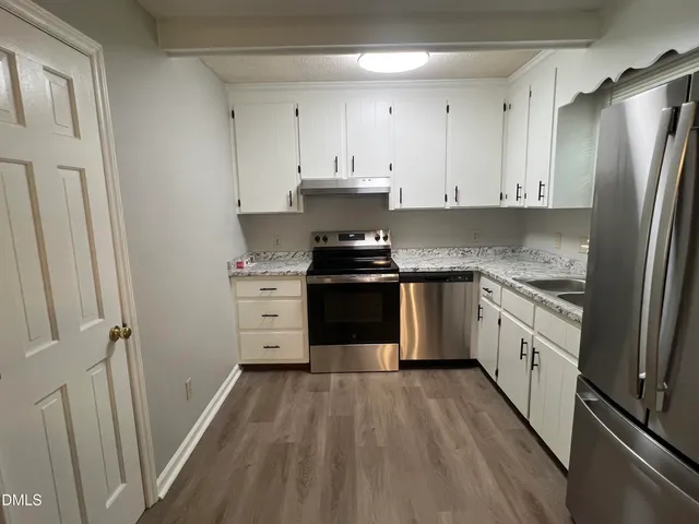 a kitchen with a stove a sink and a refrigerator
