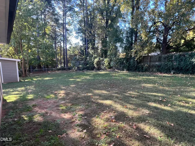 a view of a field with trees in the background