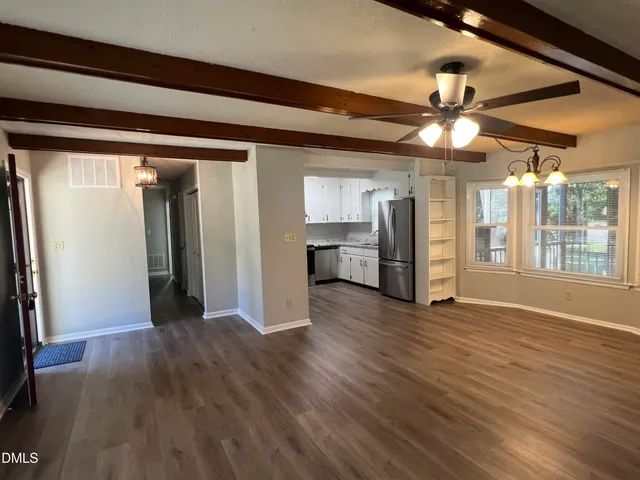 a view of a livingroom with wooden floor and a ceiling fan