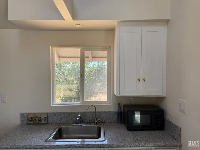an empty room with wooden floor and a way to dining room