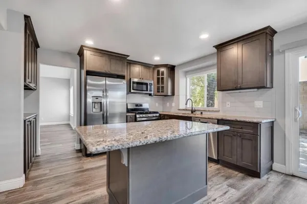 a kitchen with stainless steel appliances granite countertop a sink refrigerator and microwave