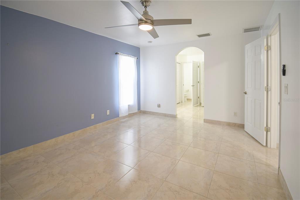 4913 Cromey Road North Port, FL 34288 - Photo 12 of 36 an empty room with chandelier fan and windows