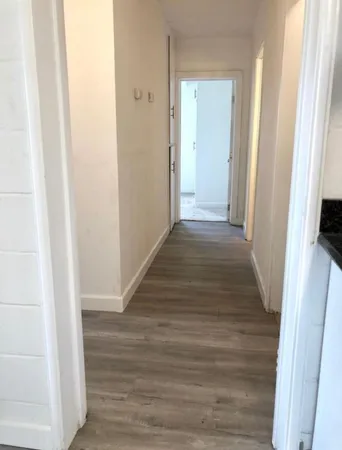 a view of a hallway with wooden floor