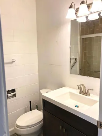 a bathroom with a sink a toilet and shower