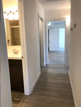 a view of a hallway with wooden floor and staircase