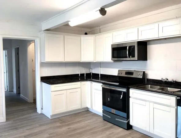 a kitchen with granite countertop a stove and a microwave