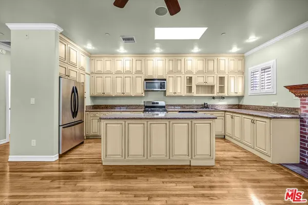 a view of a room with wooden floor a ceiling fan and window