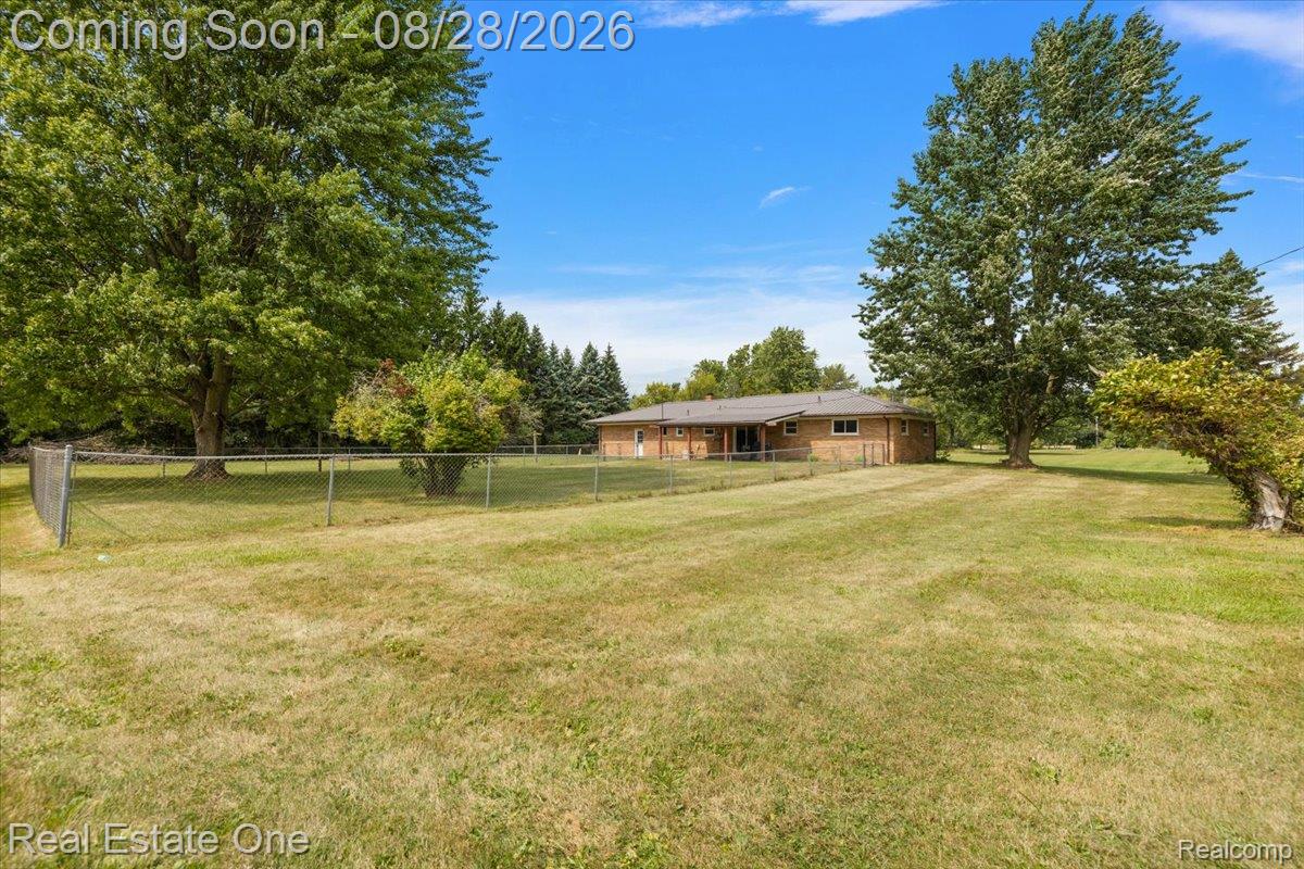 15250 34 Mile Road Armada, MI 48005 - Photo 8 of 49 Expansive rear yard featuring mature trees and a chain-link fence