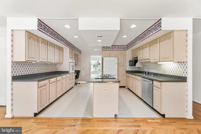 a kitchen with stainless steel appliances granite countertop a sink stove cabinets and wooden floor