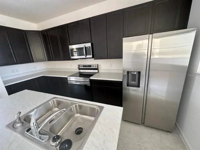 a kitchen with cabinets and refrigerator