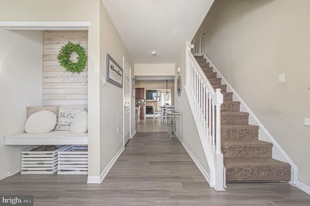 a view of a hallway with wooden floor and stairs