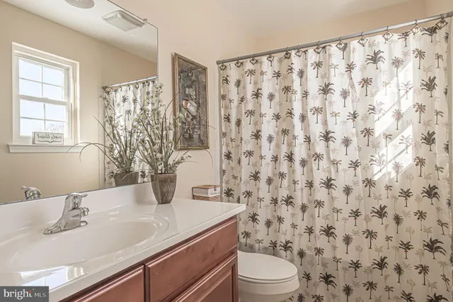 a bathroom with a granite countertop sink a toilet and a mirror
