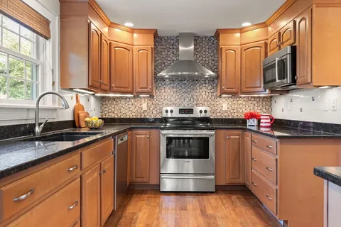 a kitchen with stainless steel appliances granite countertop a sink stove and microwave