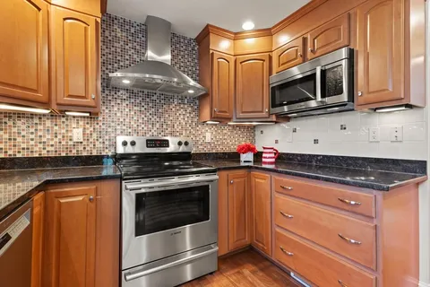 a kitchen with stainless steel appliances granite countertop a stove microwave and cabinets