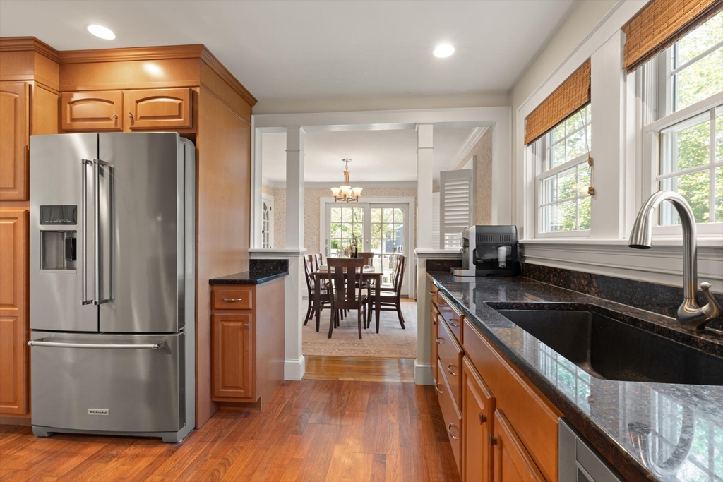 89 Dwinell Street Boston, MA 02132 - Photo 14 of 37 a kitchen with granite countertop a refrigerator a sink a stove and island with wooden floor
