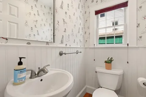 a bathroom with a sink a toilet and a window