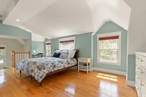 a bedroom with a bed and wooden floor