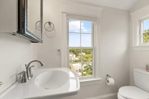 a bathroom with a sink a toilet and a window