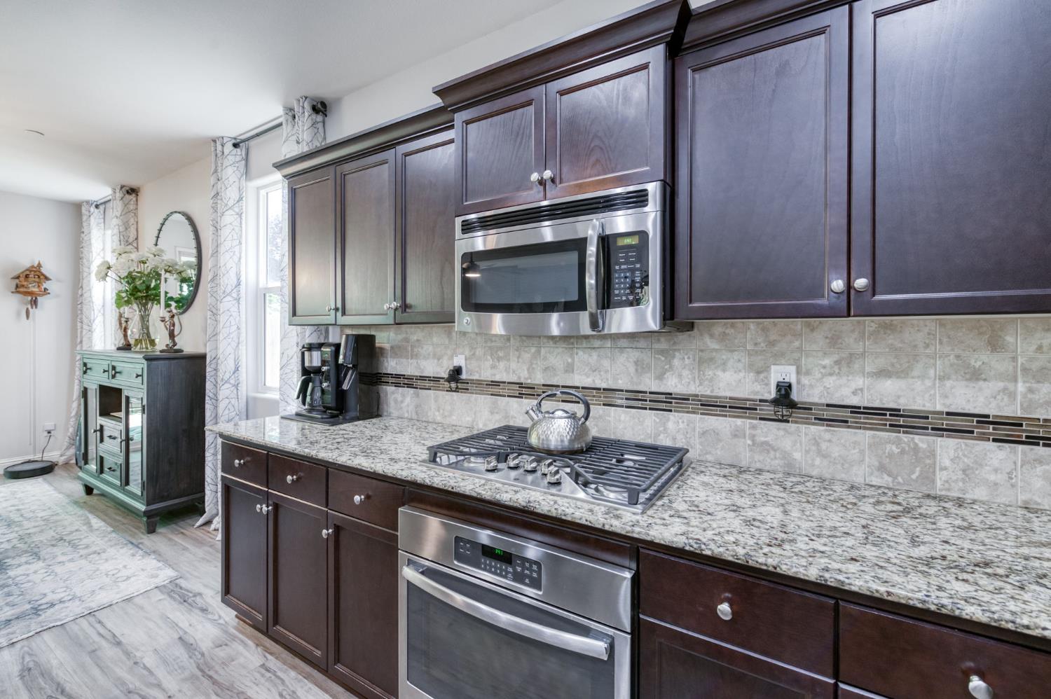 3562 Luminary Way Clovis, CA 93619 - Photo 7 of 40 a kitchen with stainless steel appliances granite countertop a sink stove and microwave