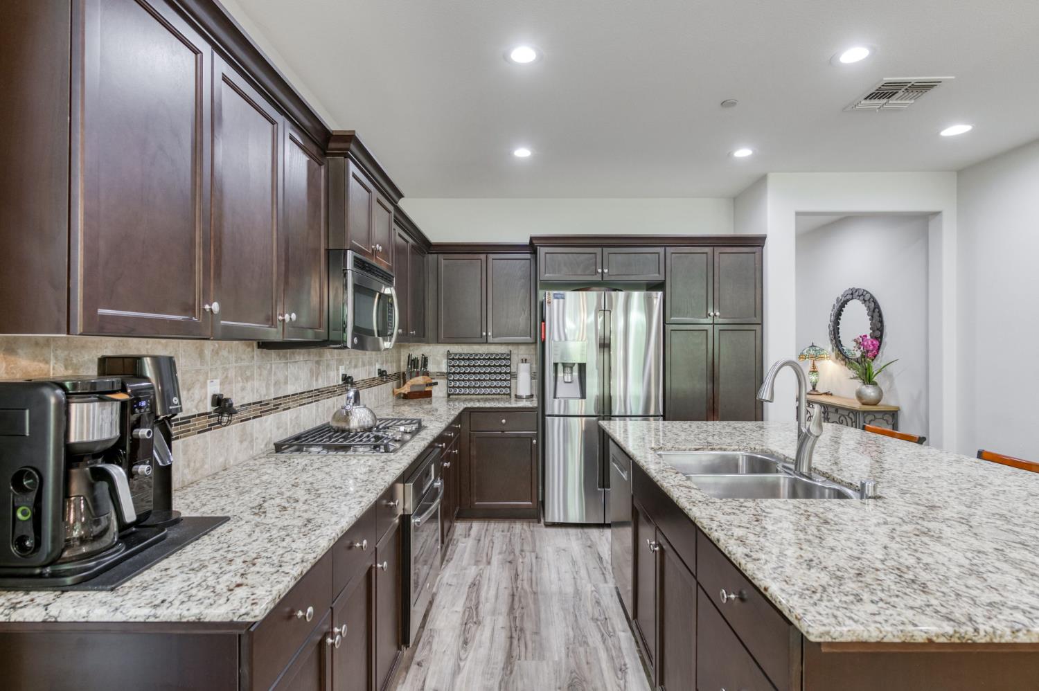 3562 Luminary Way Clovis, CA 93619 - Photo 8 of 40 a kitchen with stainless steel appliances granite countertop a sink stove and refrigerator