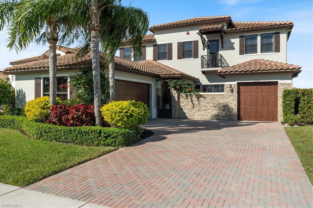 5135 Genoa Street Ave Maria, FL 34142 - Photo 1 of 35 a front view of a house with a garden and plants