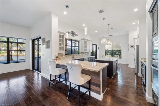 a large kitchen with cabinets a sink a counter space and stainless steel appliances