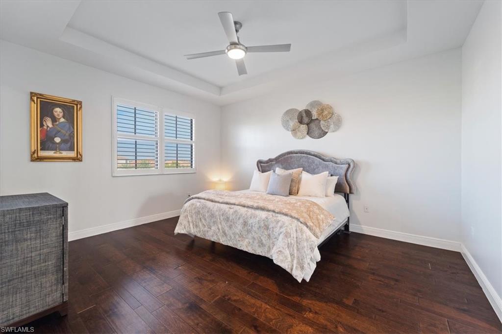 5135 Genoa Street Ave Maria, FL 34142 - Photo 18 of 35 a bedroom with a bed and wooden floor