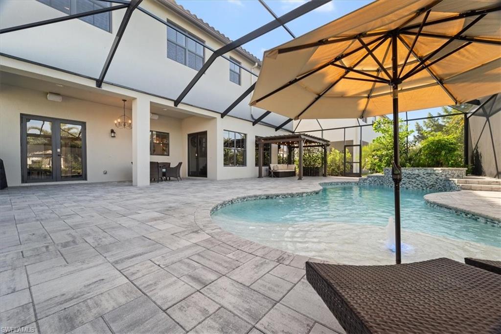 5135 Genoa Street Ave Maria, FL 34142 - Photo 6 of 35 a view of a patio with a table and chairs under an umbrella