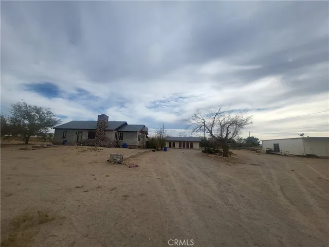 a view of a dirt road and a building in the background