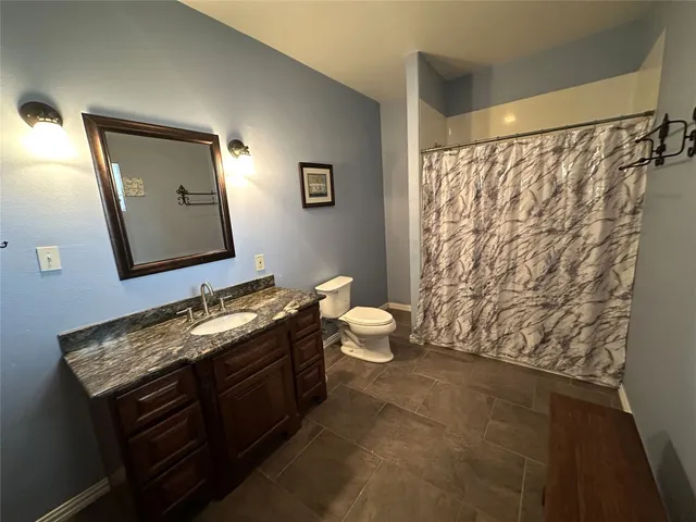 a bathroom with a granite countertop sink a mirror and shower