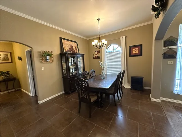 a view of a dining room with furniture and chandelier