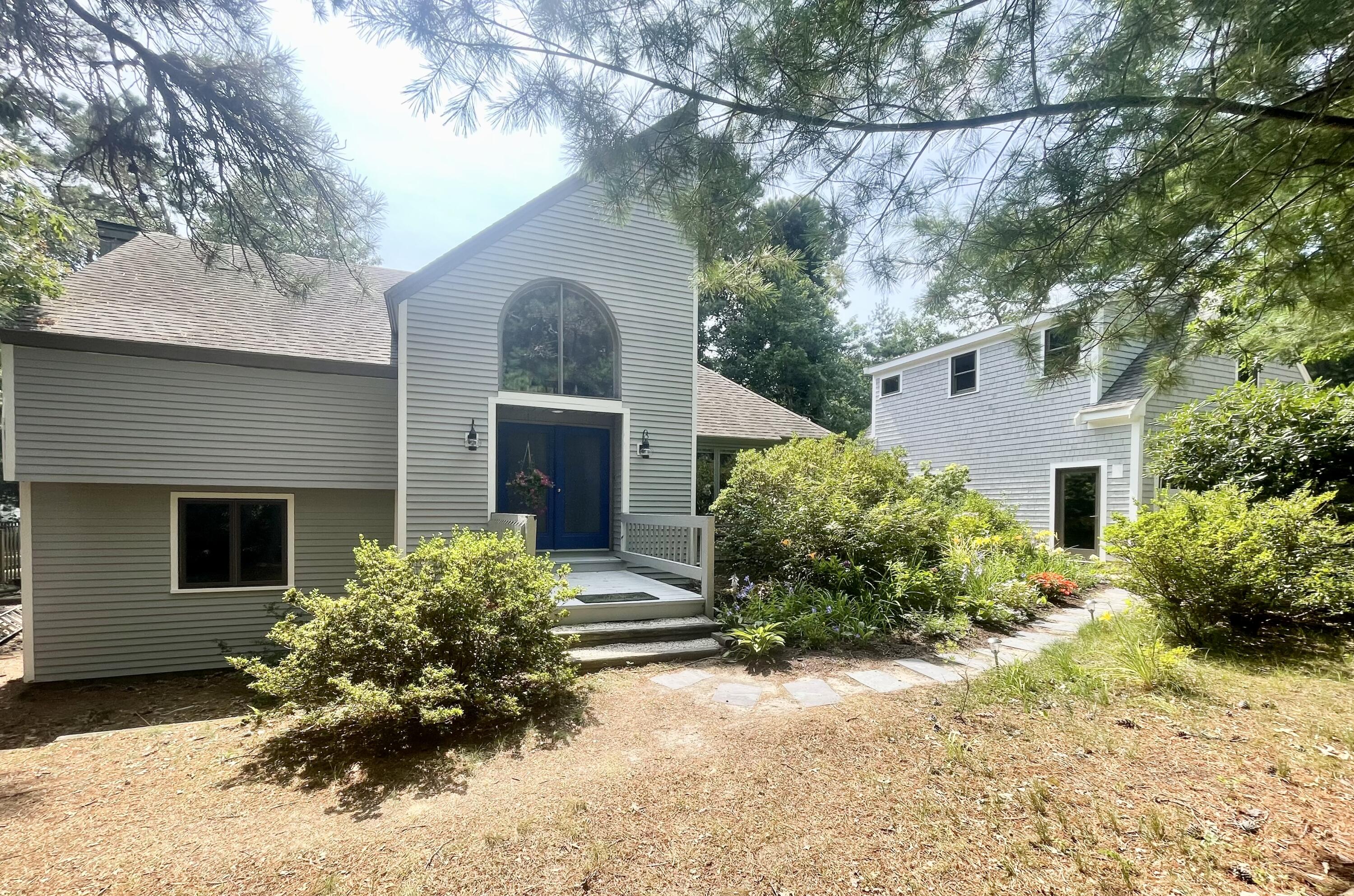87 Tracey Road Cotuit, MA 02635 - Photo 4 of 33 a front view of a house with a yard and garage