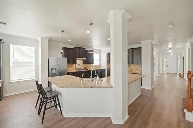 a kitchen with a table chairs refrigerator and cabinets