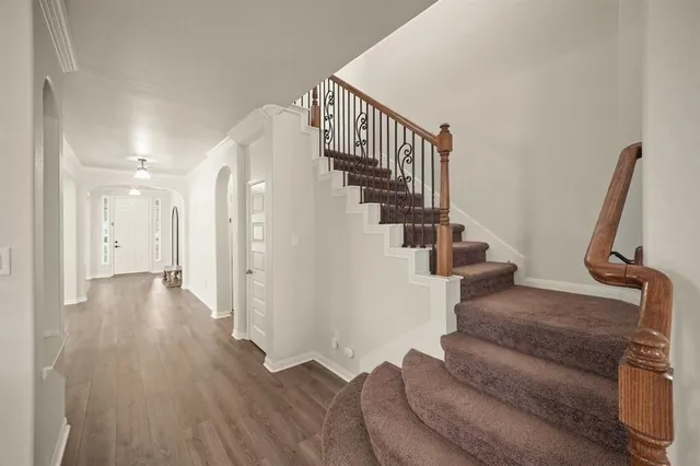 a view of entryway and hall with wooden floor