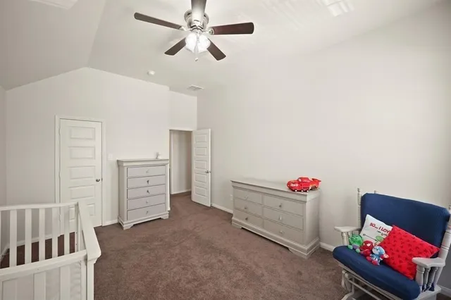 a bedroom with furniture and a chandelier fan