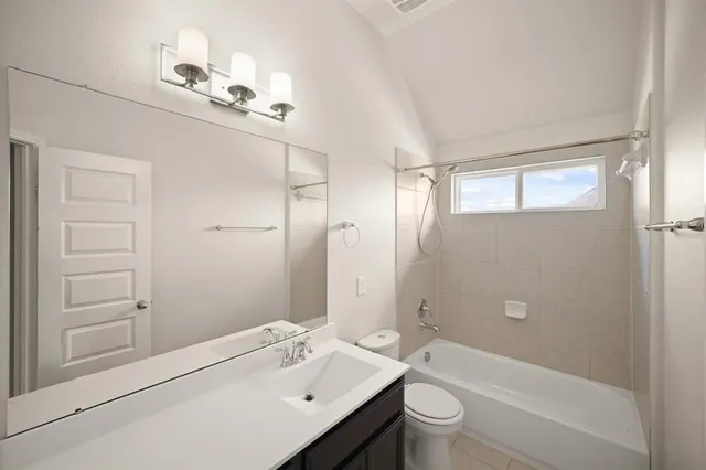 a bathroom with a bathtub shower sink vanity and toilet