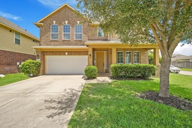 a front view of a house with a yard and trees