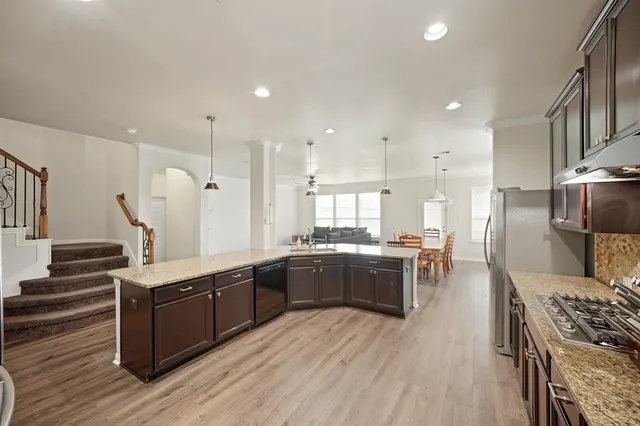 a large kitchen with stainless steel appliances and a large counter top